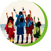 Quelle: BDKJ Freiburg Vier Kinder am Strand mit hochgereckten Fäusten, tragen bunte Superhelden-Capes und Sportkleidung